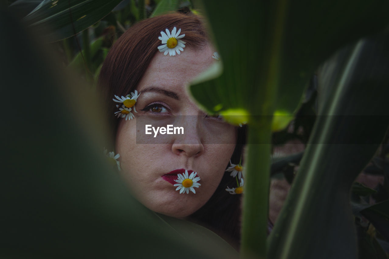 Close-up of young woman with flower