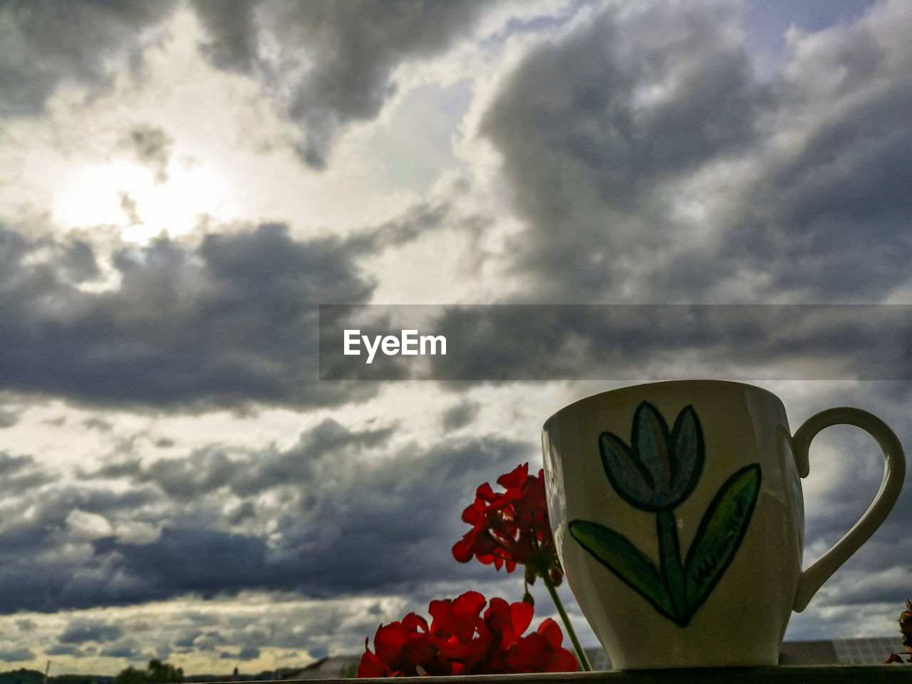 HEART SHAPE MADE FROM COFFEE CUP AGAINST SKY DURING SUNSET