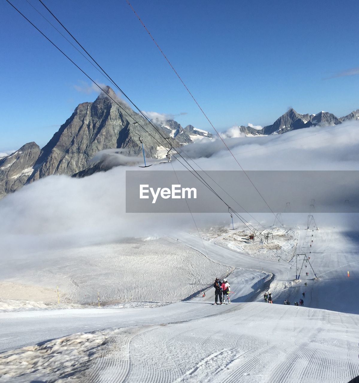 PEOPLE ON SNOWCAPPED MOUNTAINS AGAINST SKY