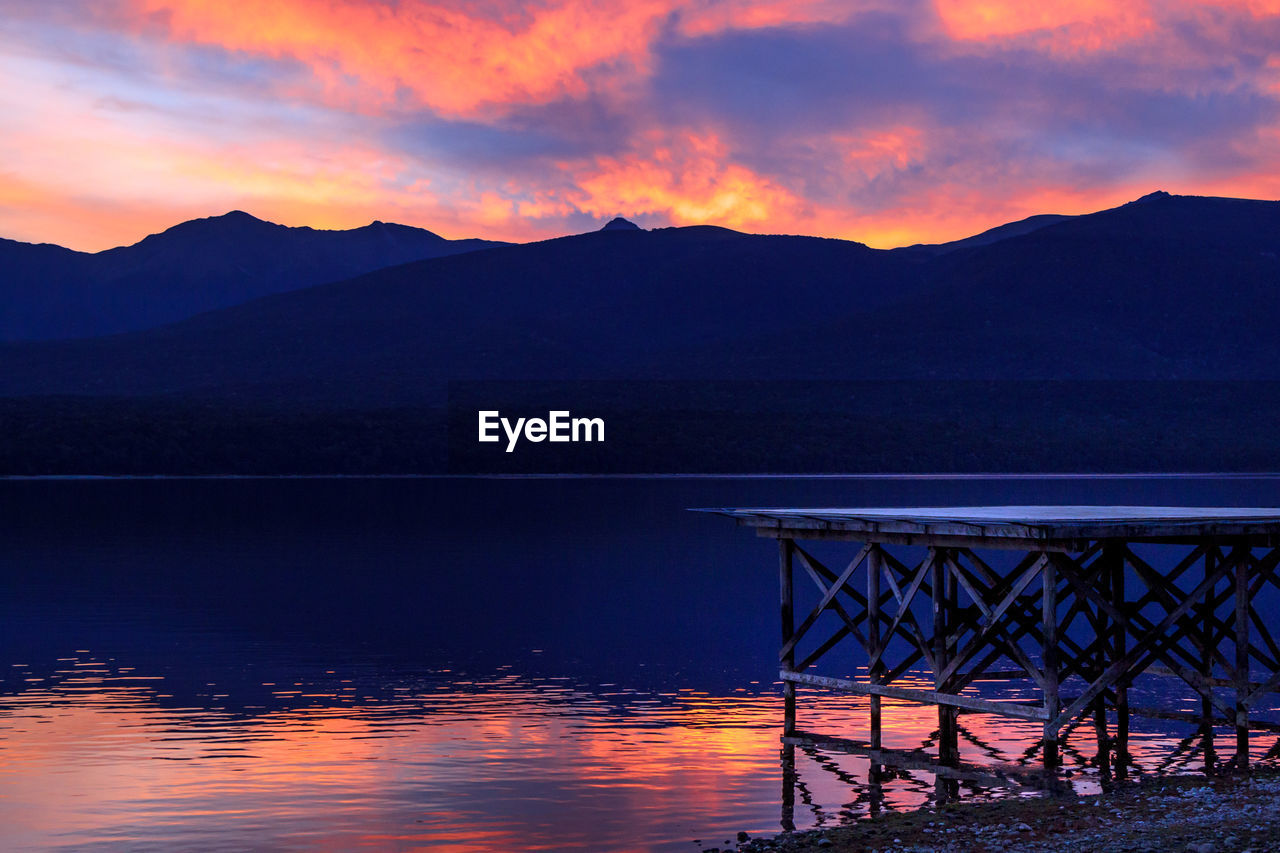 Scenic view of lake against sky at sunset