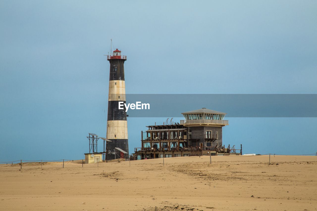 LIGHTHOUSE BY SEA AGAINST SKY