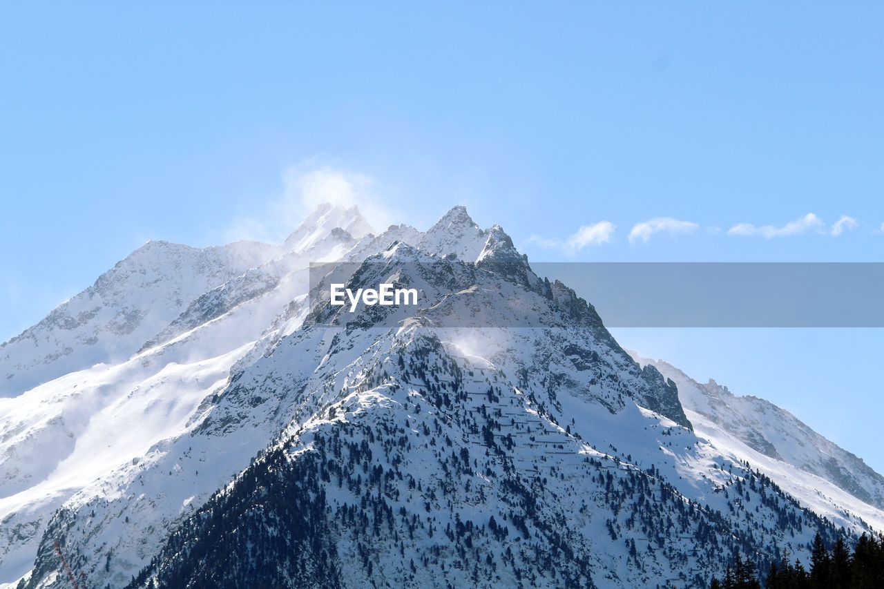 Low angle view of snowcapped mountains against sky