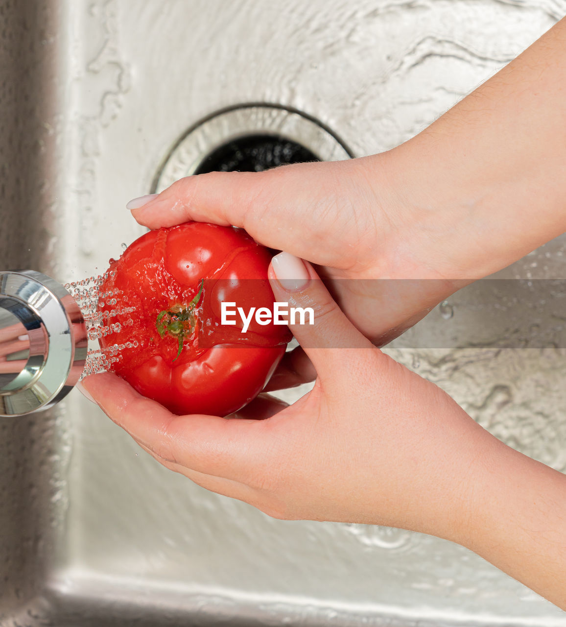 hand, sink, fruit, domestic room, home, washing, one person, domestic kitchen, women, holding, cleaning, food and drink, adult, domestic life, kitchen, food, red, healthy eating, indoors, tomato, lifestyles, wellbeing, household equipment, strawberry, kitchen sink, produce, vegetable, faucet, water, housework, hygiene, freshness, female, plant, close-up, home interior, high angle view, running water