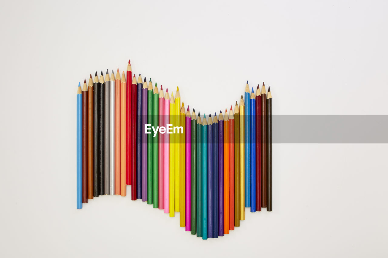 High angle view of colored pencils on white background