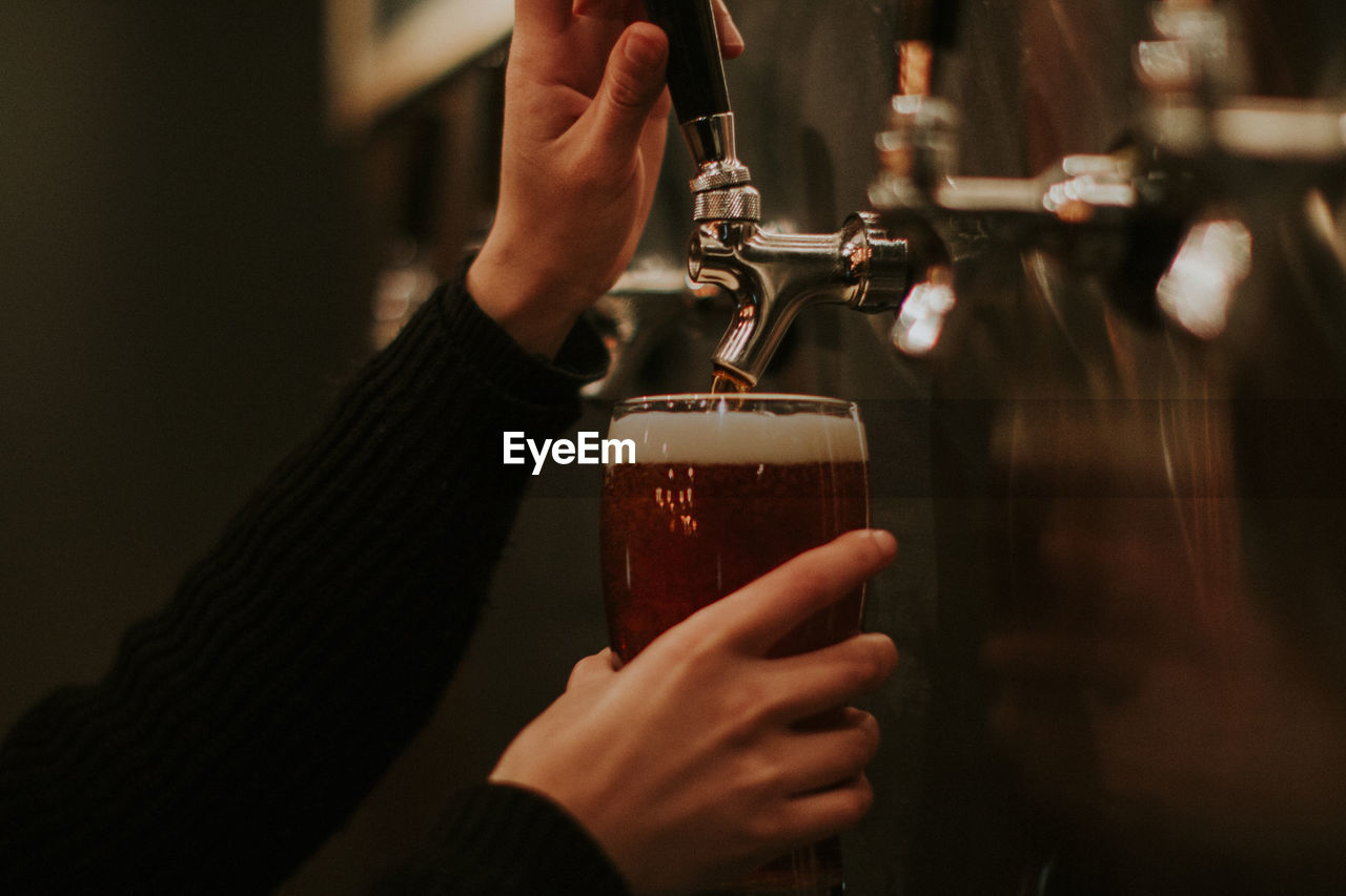 Female hands pouring beer