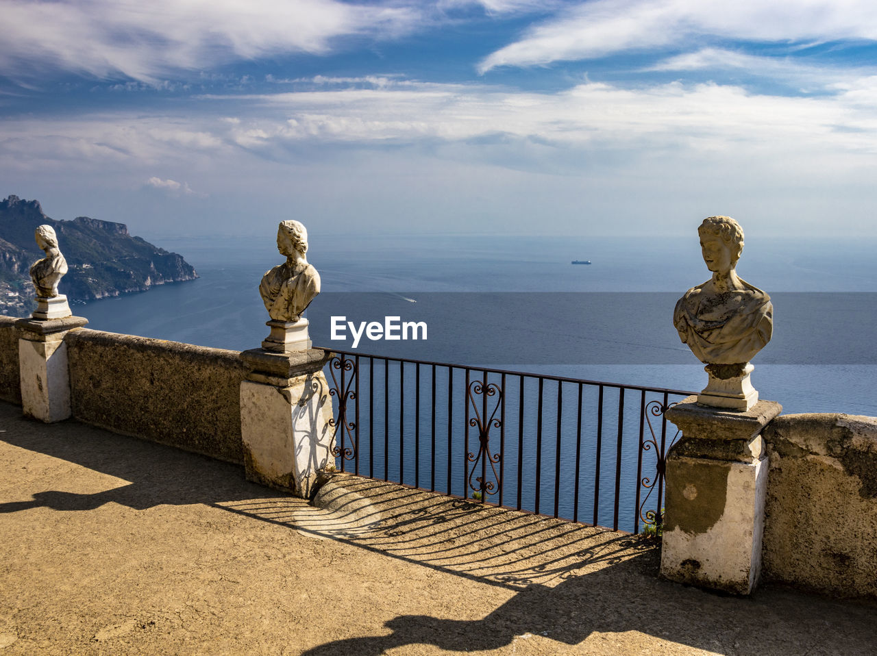 STATUE BY RAILING AGAINST SEA