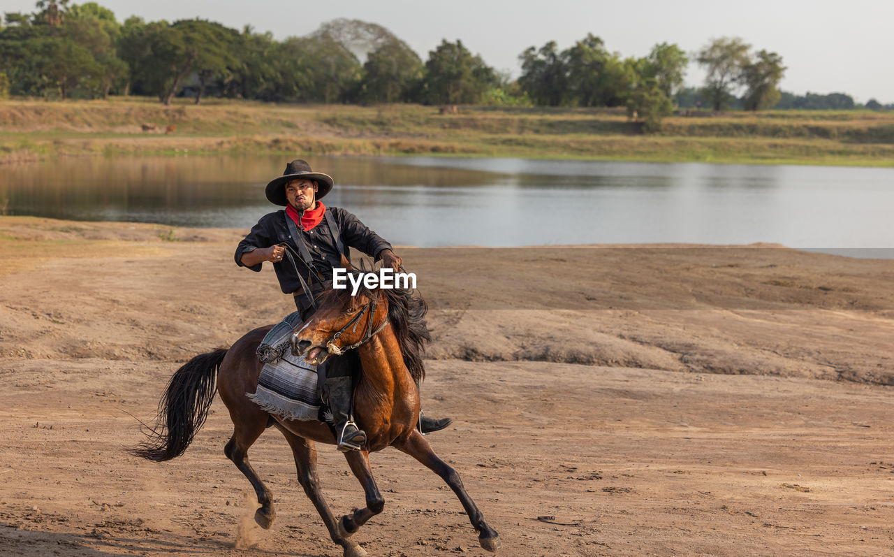 Cowboy's way of life include riding a horse around locales.