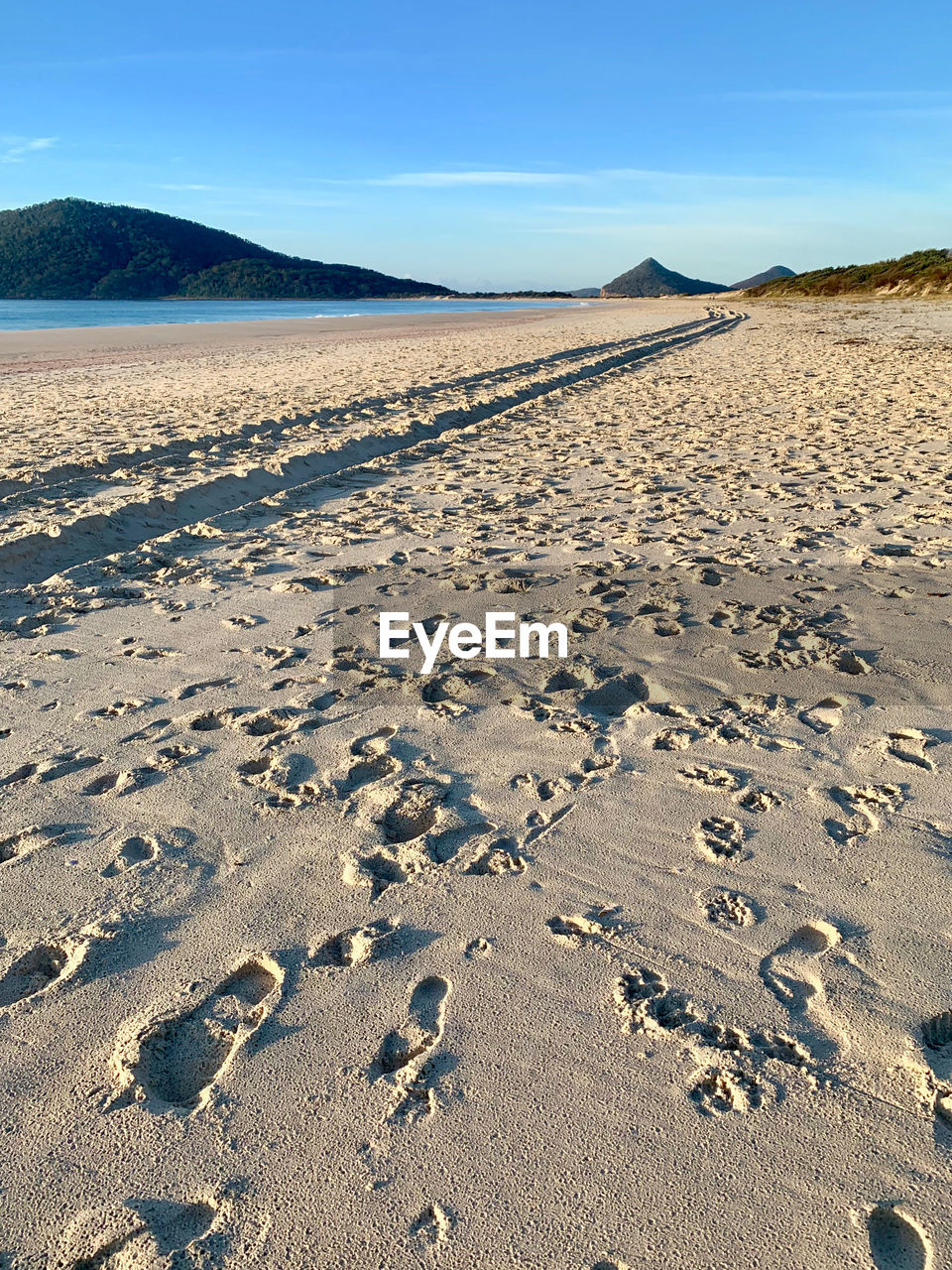 VIEW OF FOOTPRINTS ON SAND AT BEACH AGAINST SKY