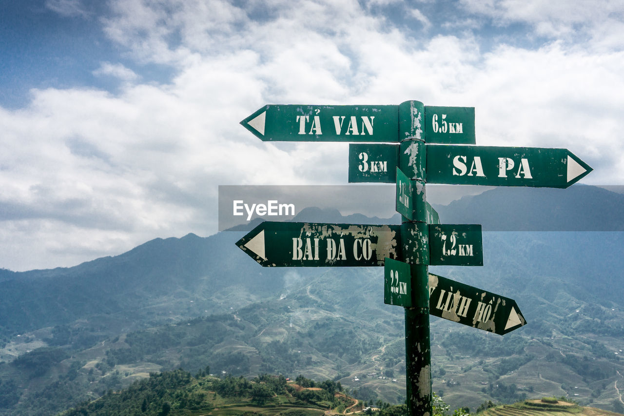 INFORMATION SIGN ON MOUNTAIN AGAINST SKY