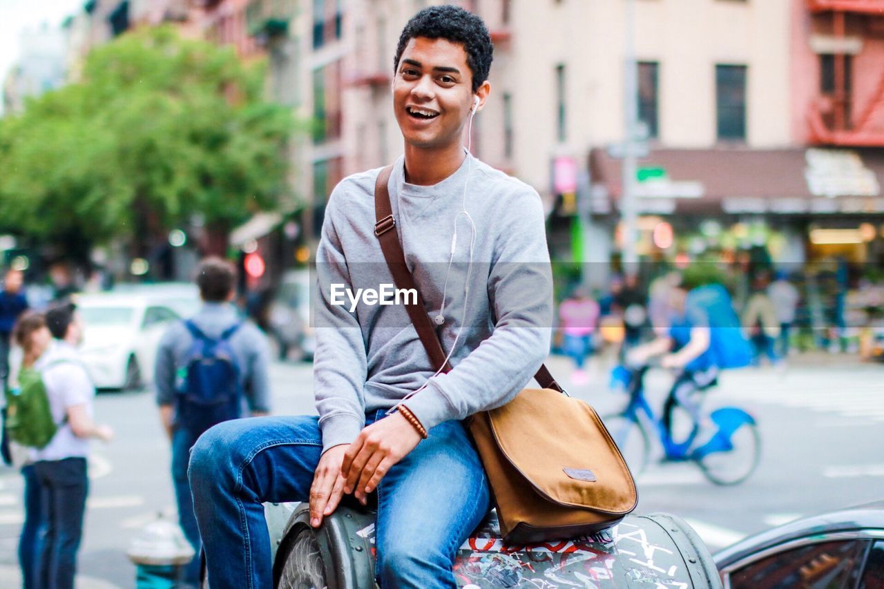 Portrait of young man by street in city