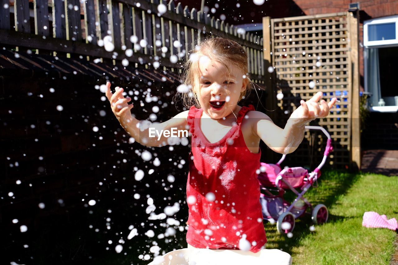 Portrait of happy girl playing in water