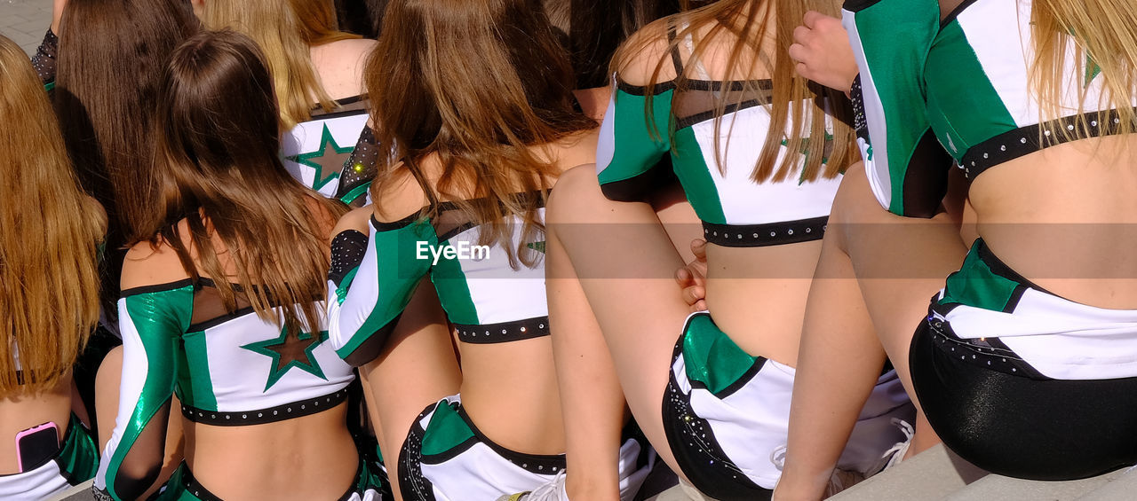 Rear view of cheerleaders sitting on steps