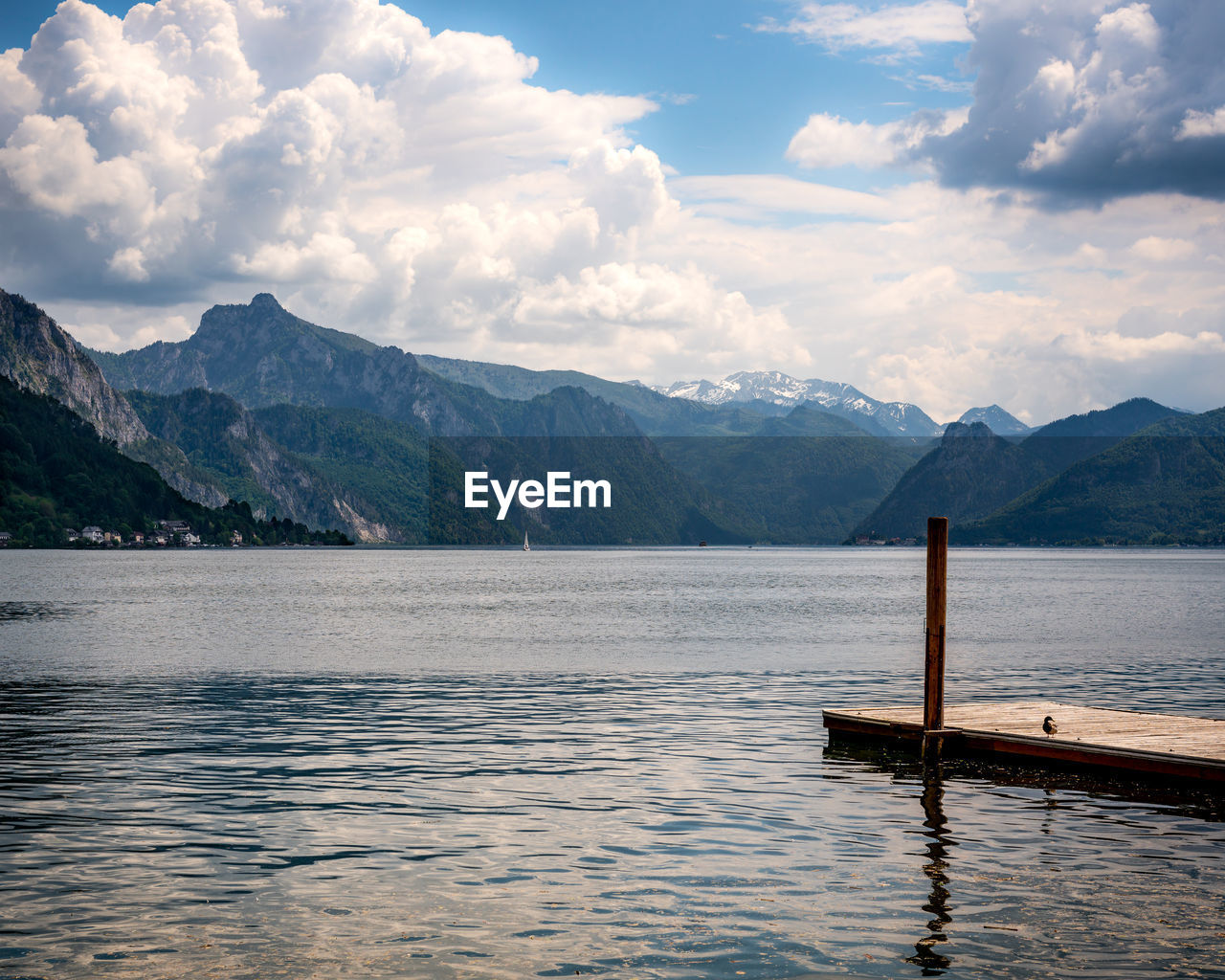 Mountain and lake view of traunsee lake, wooden dock and a bird