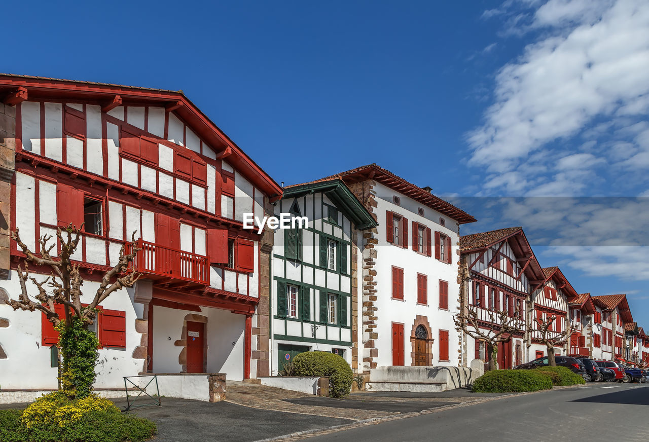 BUILDINGS BY ROAD AGAINST SKY