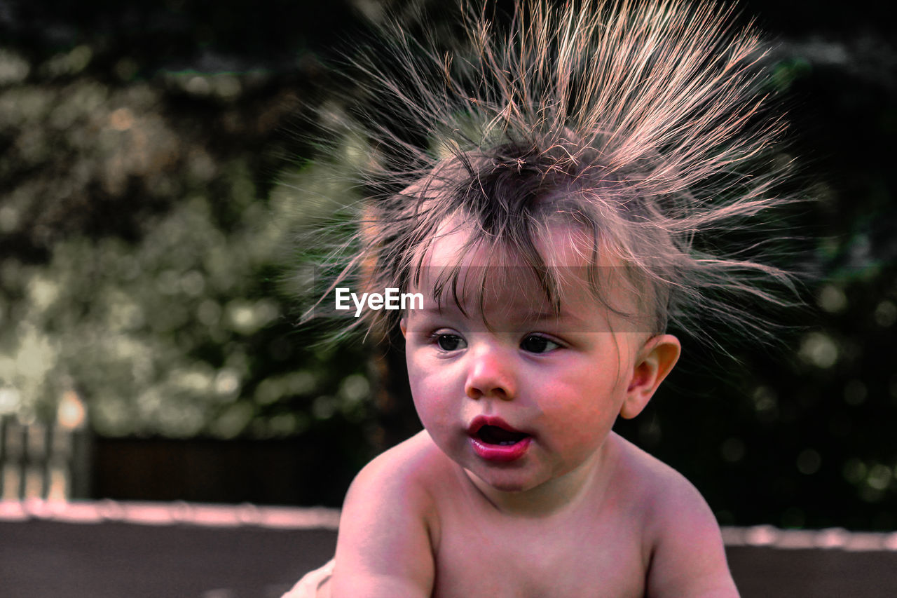 Close-up of cute baby boy with hairstyle