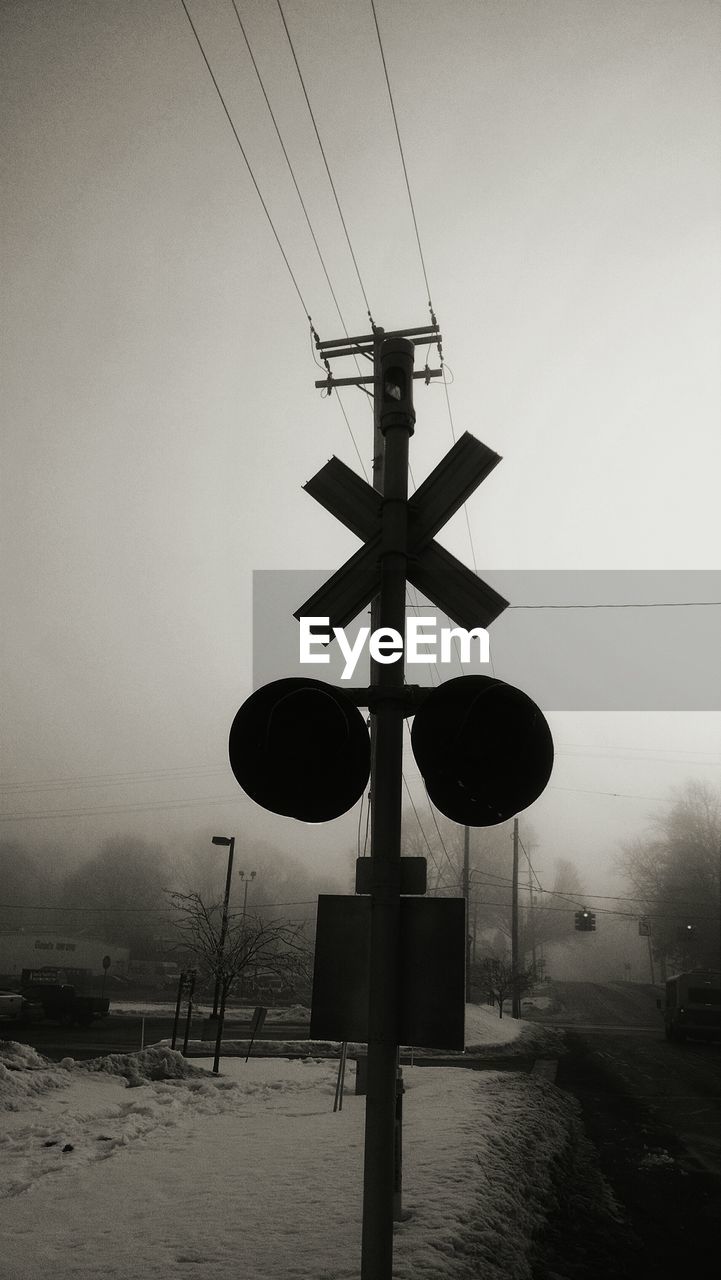 Silhouette railroad crossing in foggy weather