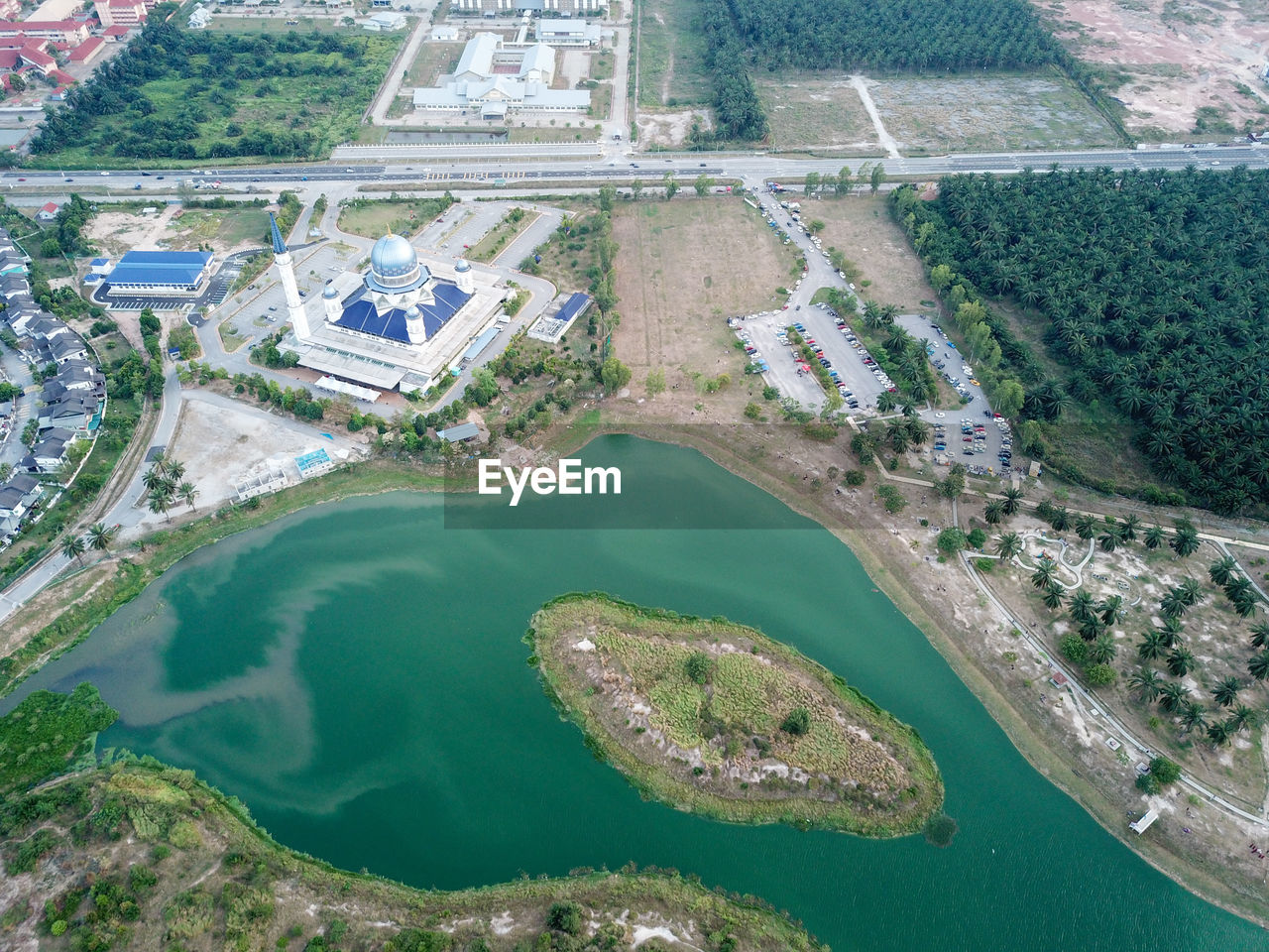 Drone view abdullah fahim mosque with green lake beside.