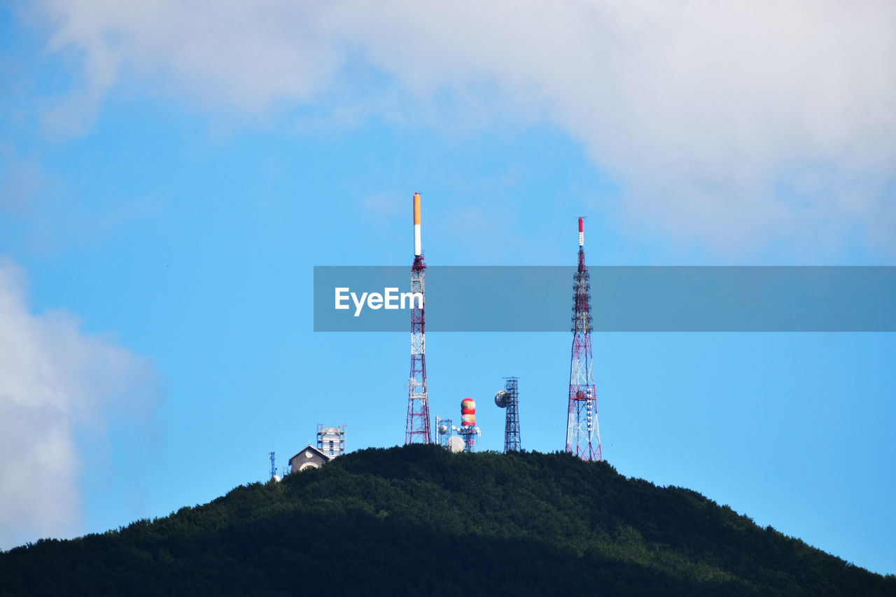 sky, tower, technology, mountain, communication, cloud, nature, communications tower, broadcasting, built structure, architecture, wireless technology, industry, global communications, low angle view, blue, telecommunications equipment, environment, outdoors, day, no people, antenna, satellite dish, business finance and industry, power generation, building exterior