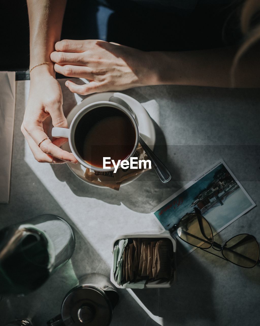 Cropped image of woman having coffee at table