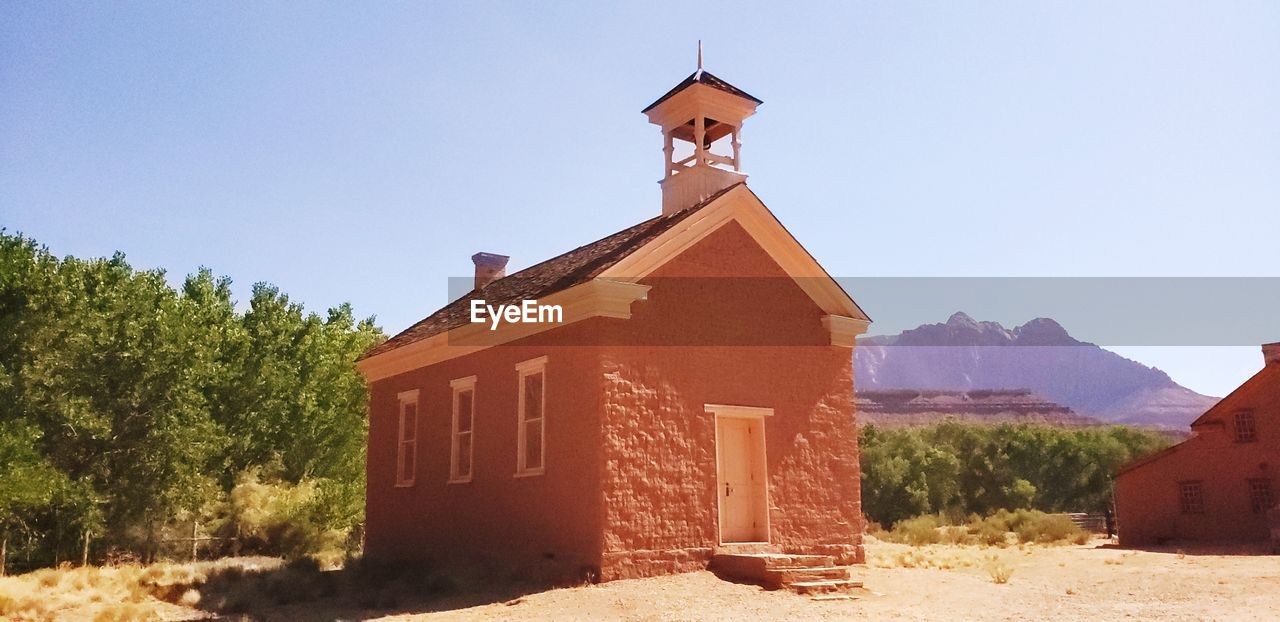 TRADITIONAL BUILDING BY TREES AGAINST SKY