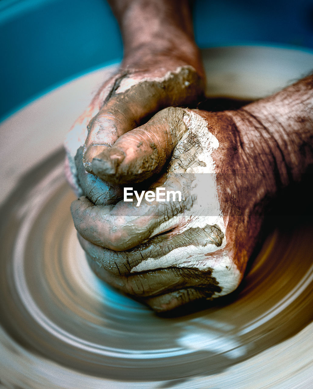 Close-up of human hands making pottery