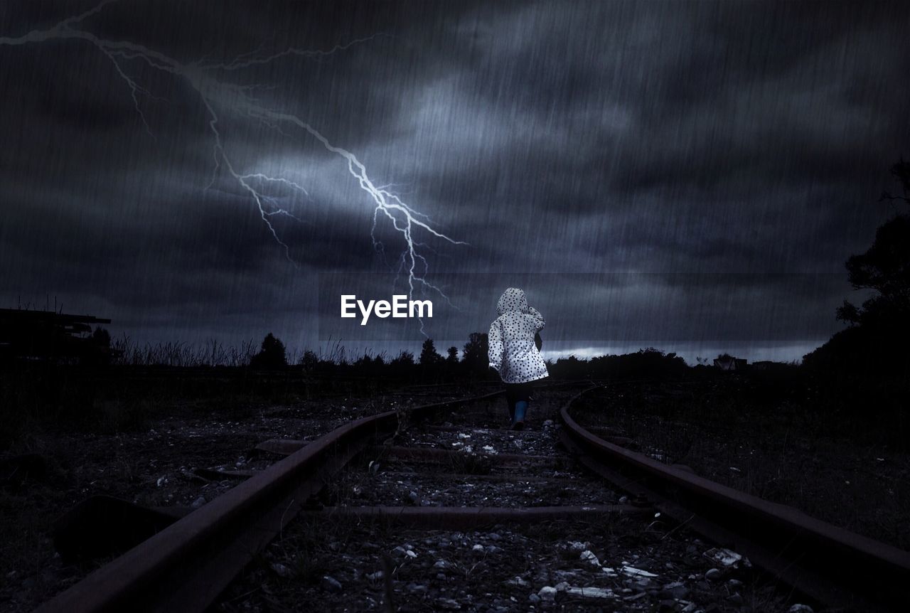 VIEW OF RAILROAD TRACKS AGAINST CLOUDY SKY