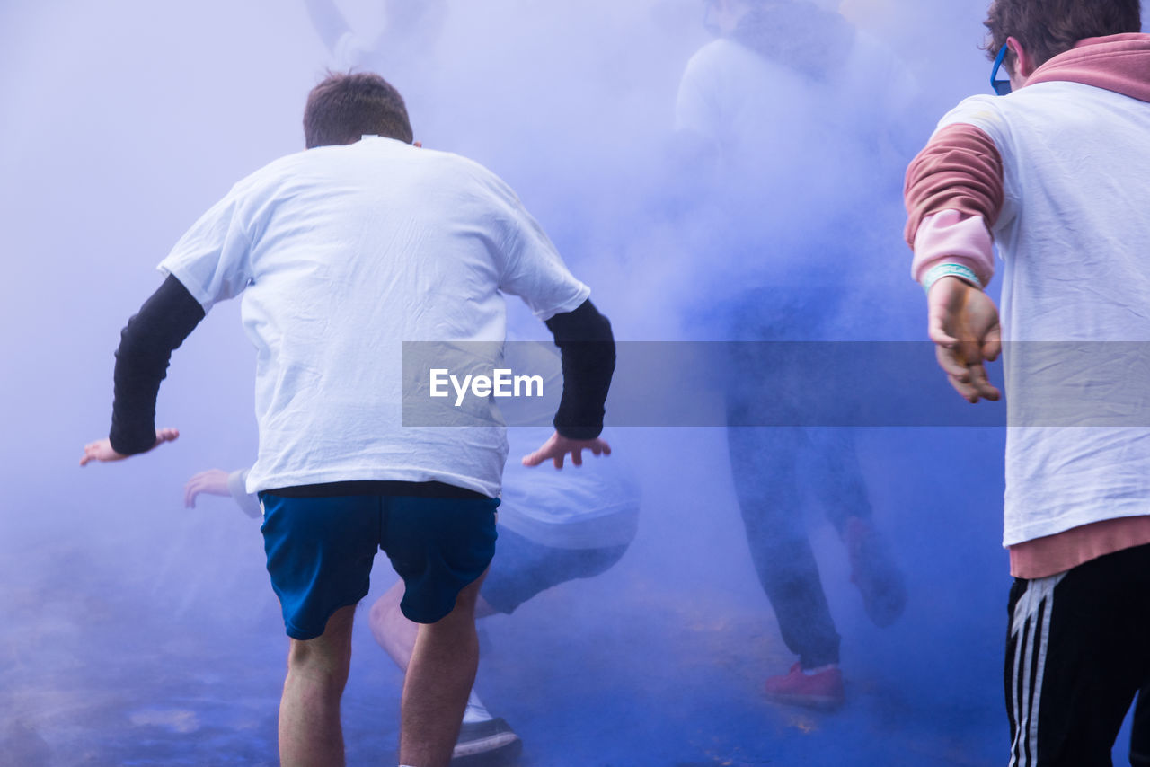 People running amidst powder paint in city