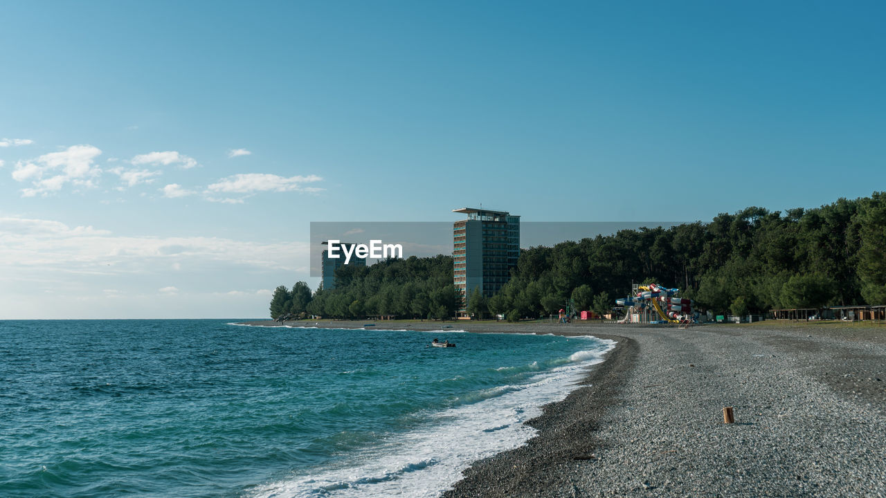 SCENIC VIEW OF SEA AND BUILDINGS AGAINST SKY