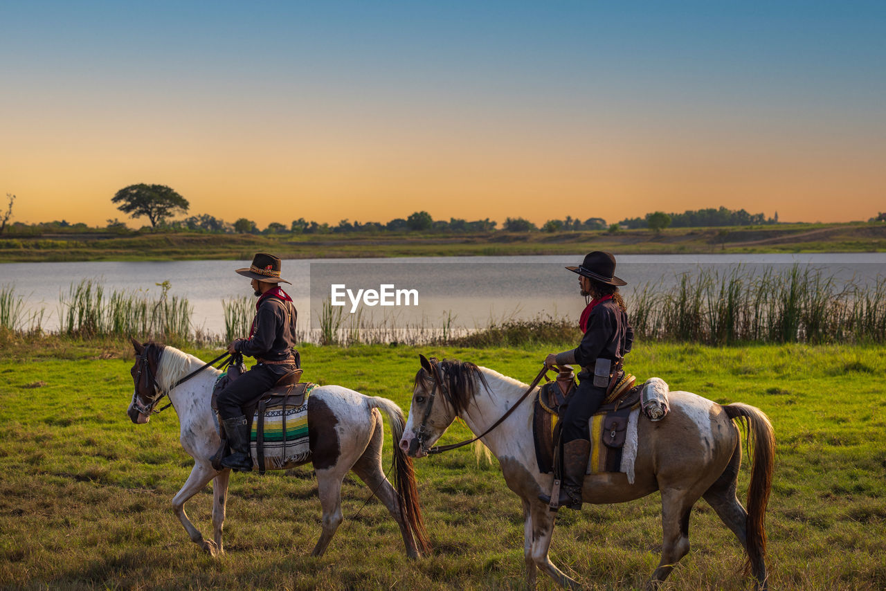 Cowboy's way of life include riding a horse around locales.