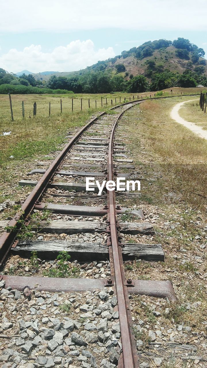 Railroad tracks by trees against sky