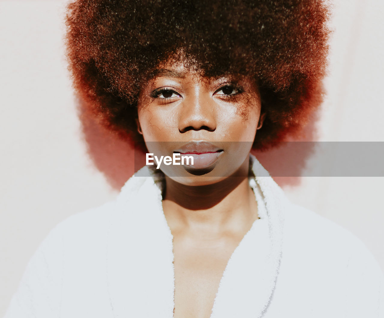 Portrait of young woman with curly hair against white background