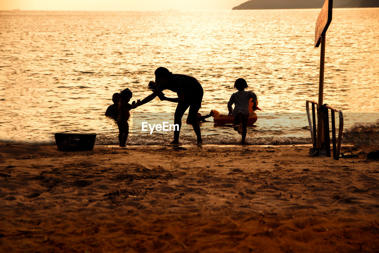 SILHOUETTE PEOPLE AT BEACH DURING SUNSET