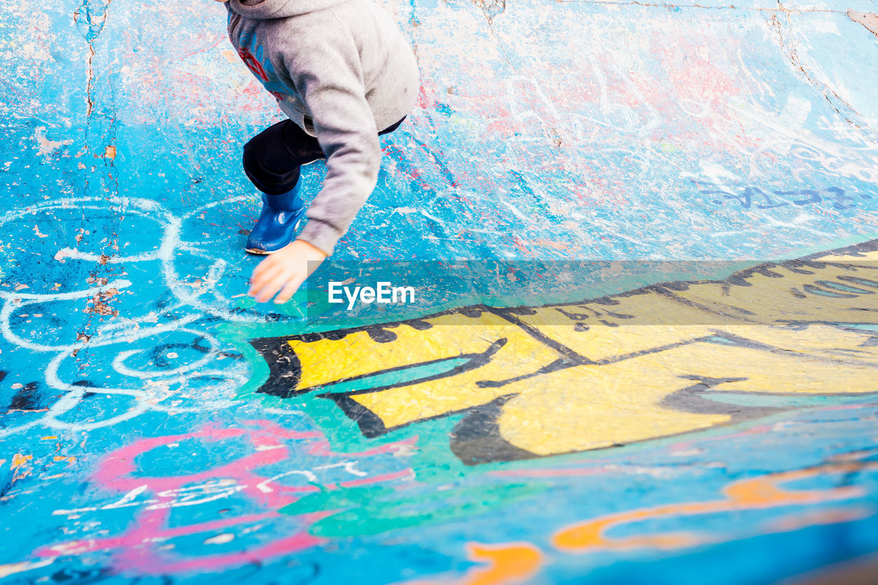 HIGH ANGLE VIEW OF MAN PAINTING ON WALL