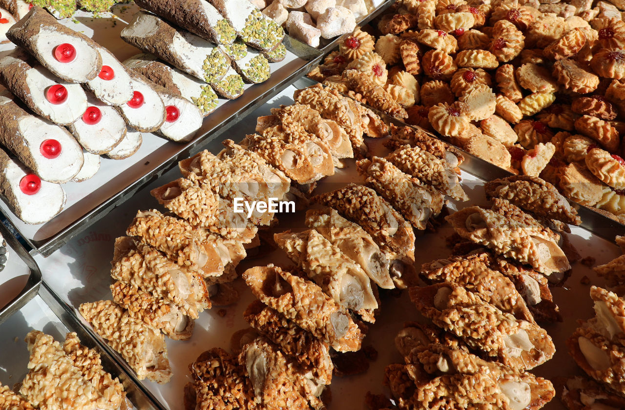 Many pastries with pistachio and cherries for sale in the italian pastry stand