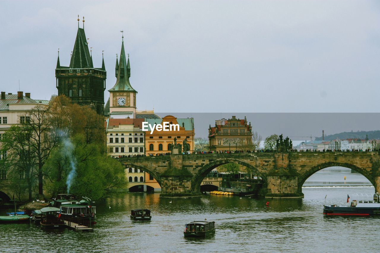 Bridge over river against buildings in city