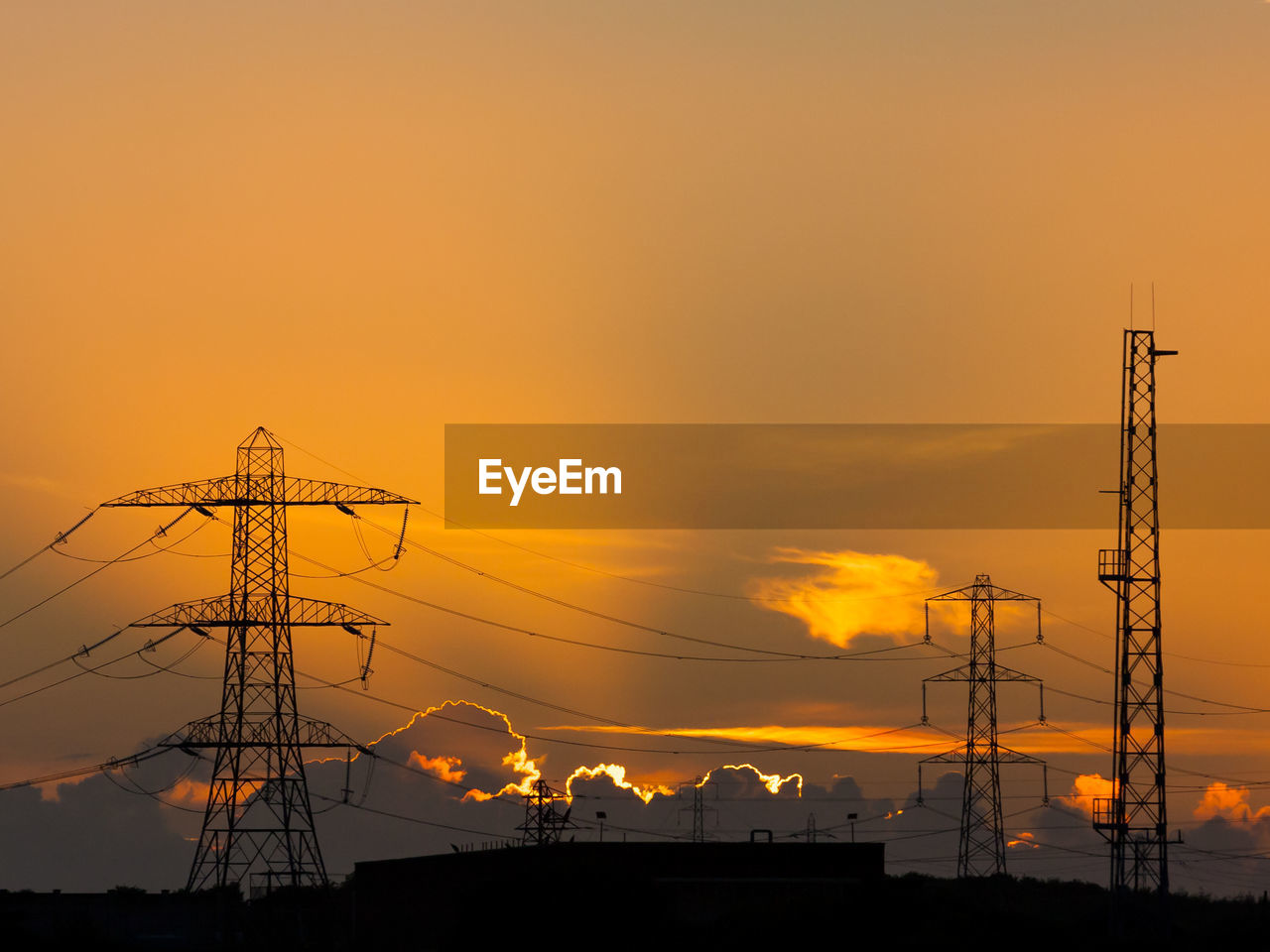 LOW ANGLE VIEW OF SILHOUETTE ELECTRICITY PYLONS AGAINST SKY DURING SUNSET