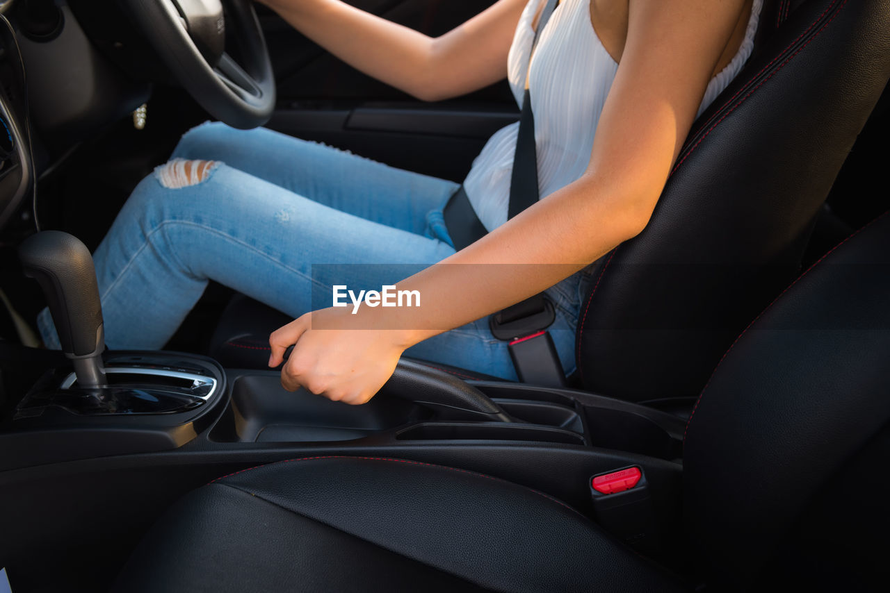 Midsection of woman sitting in car