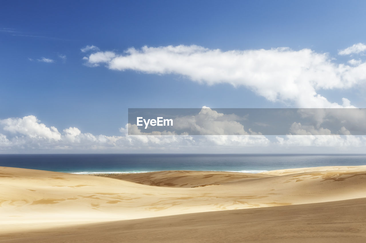 Scenic view of beach against blue sky