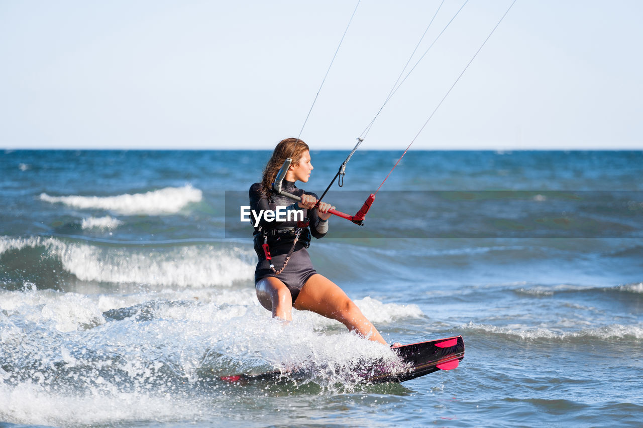 full length of man surfing on sea against clear sky