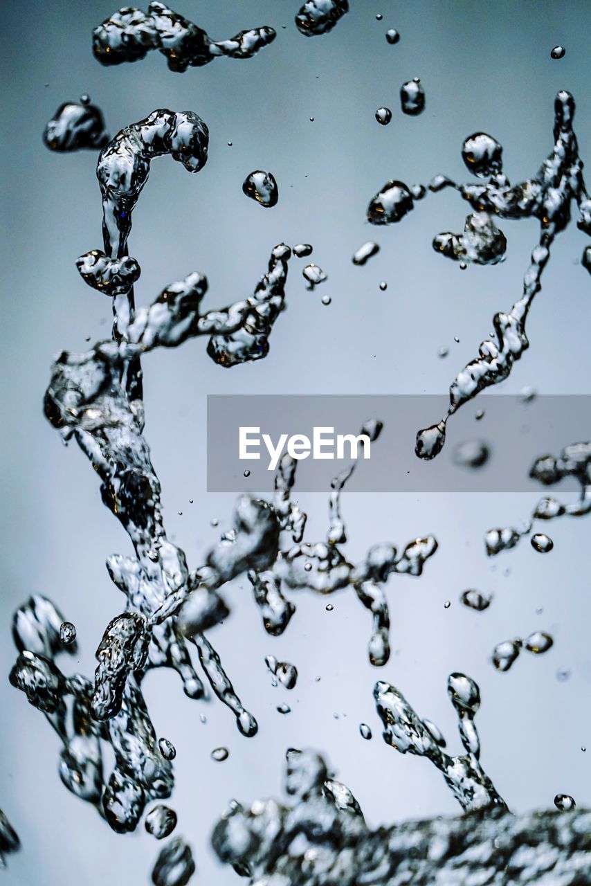 Close-up of water drops on ice against sky