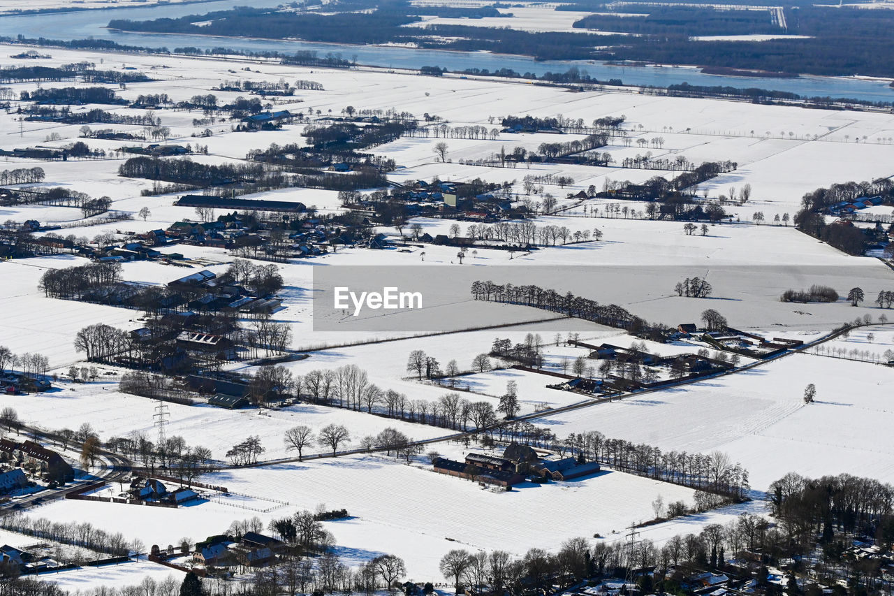 HIGH ANGLE VIEW OF SNOW COVERED FIELD AGAINST TREES