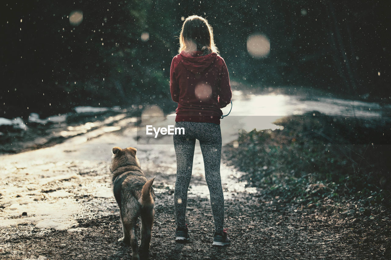 Full length of woman with dog in snow