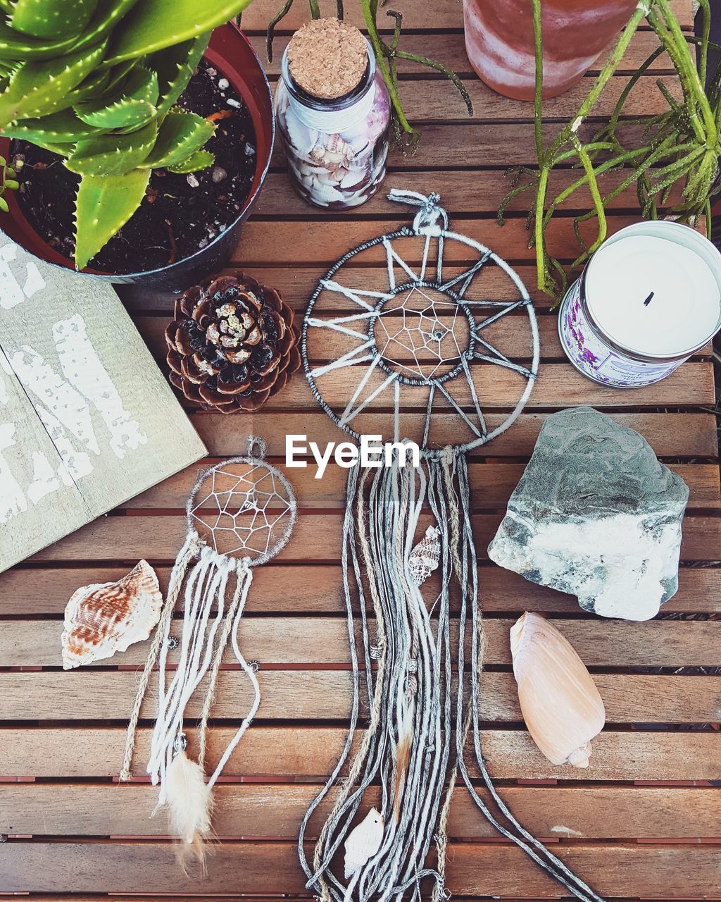 High angle view of dreamcatchers with plant and candle on table