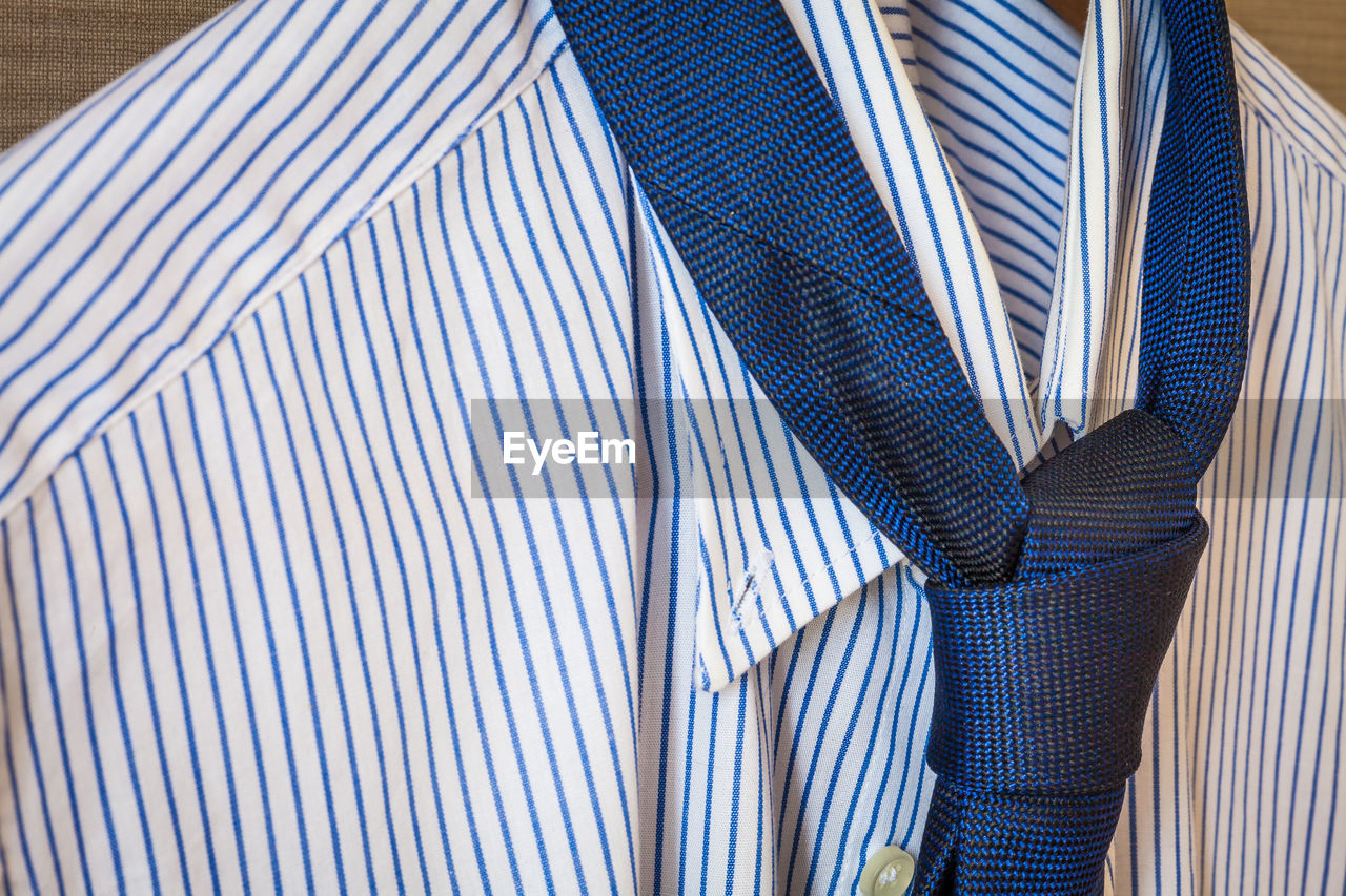 Close-up of shirt and necktie hanging on coathanger
