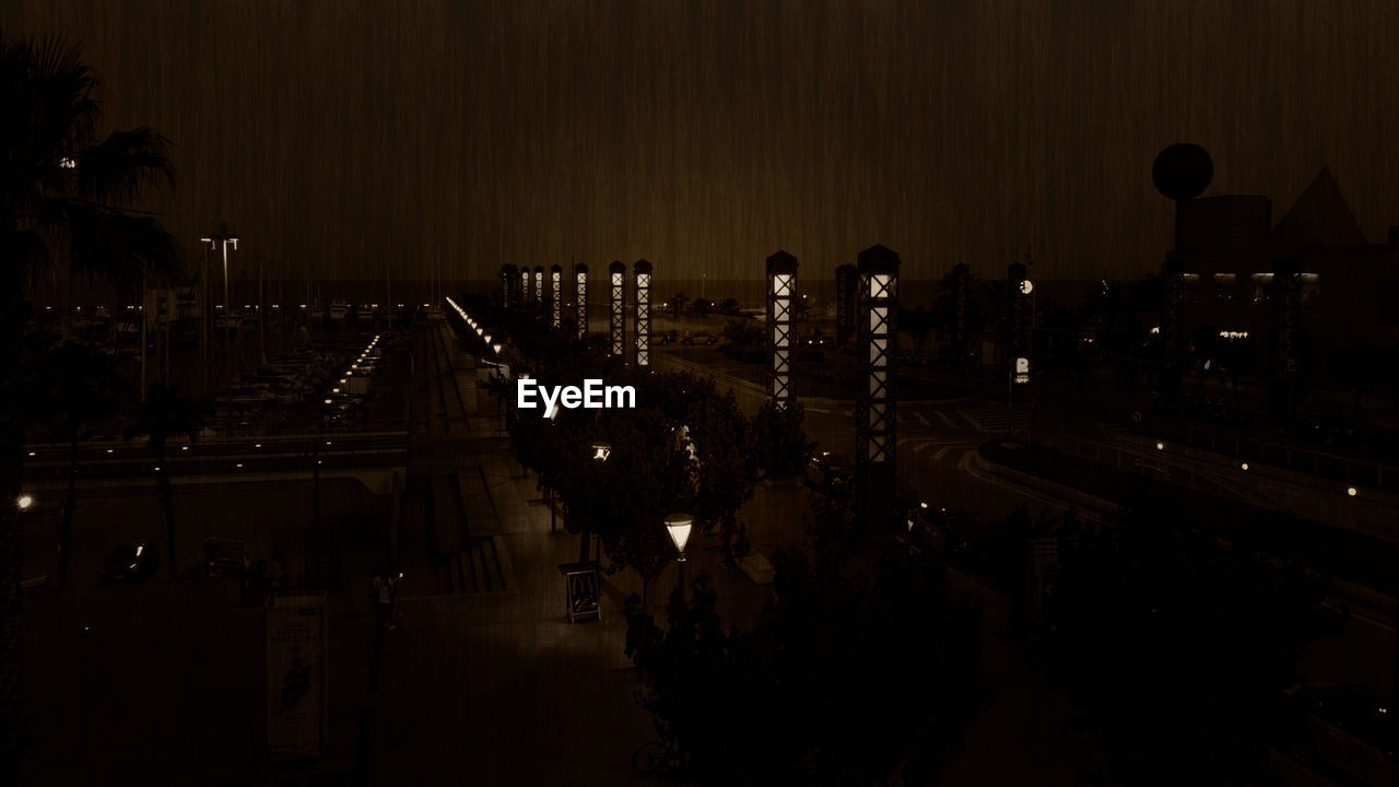 HIGH ANGLE VIEW OF ILLUMINATED BUILDINGS AT NIGHT