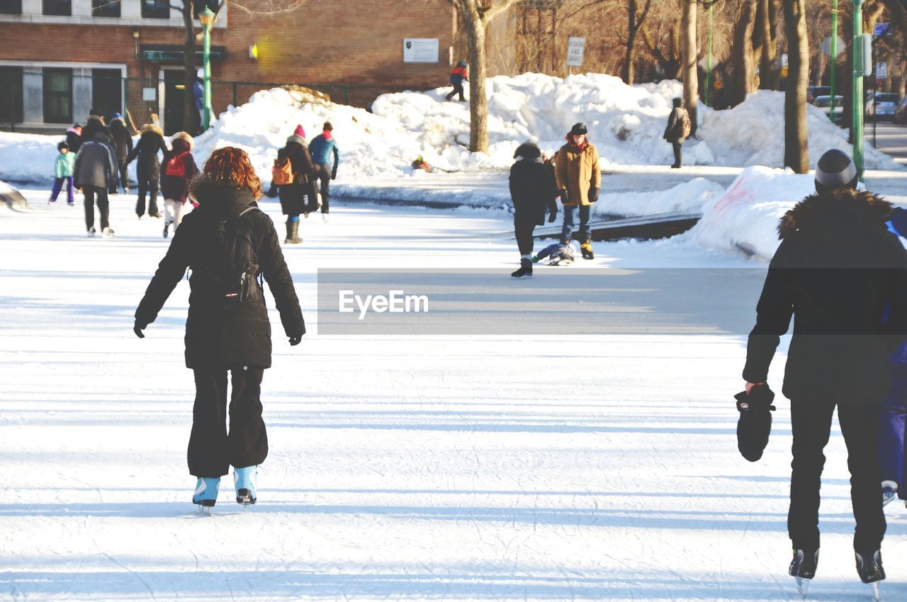 People ice-skating on snow covered field