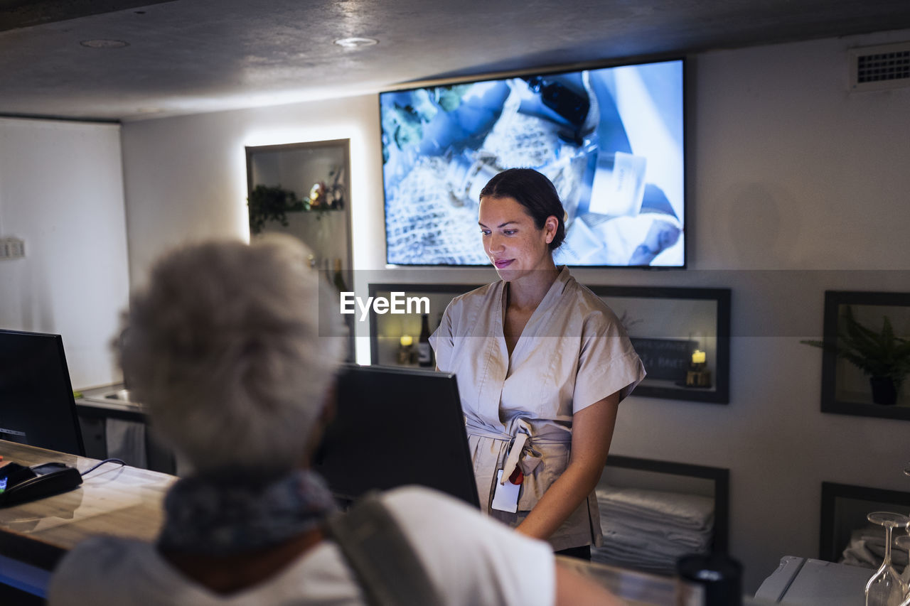 Receptionist assisting customer at health spa