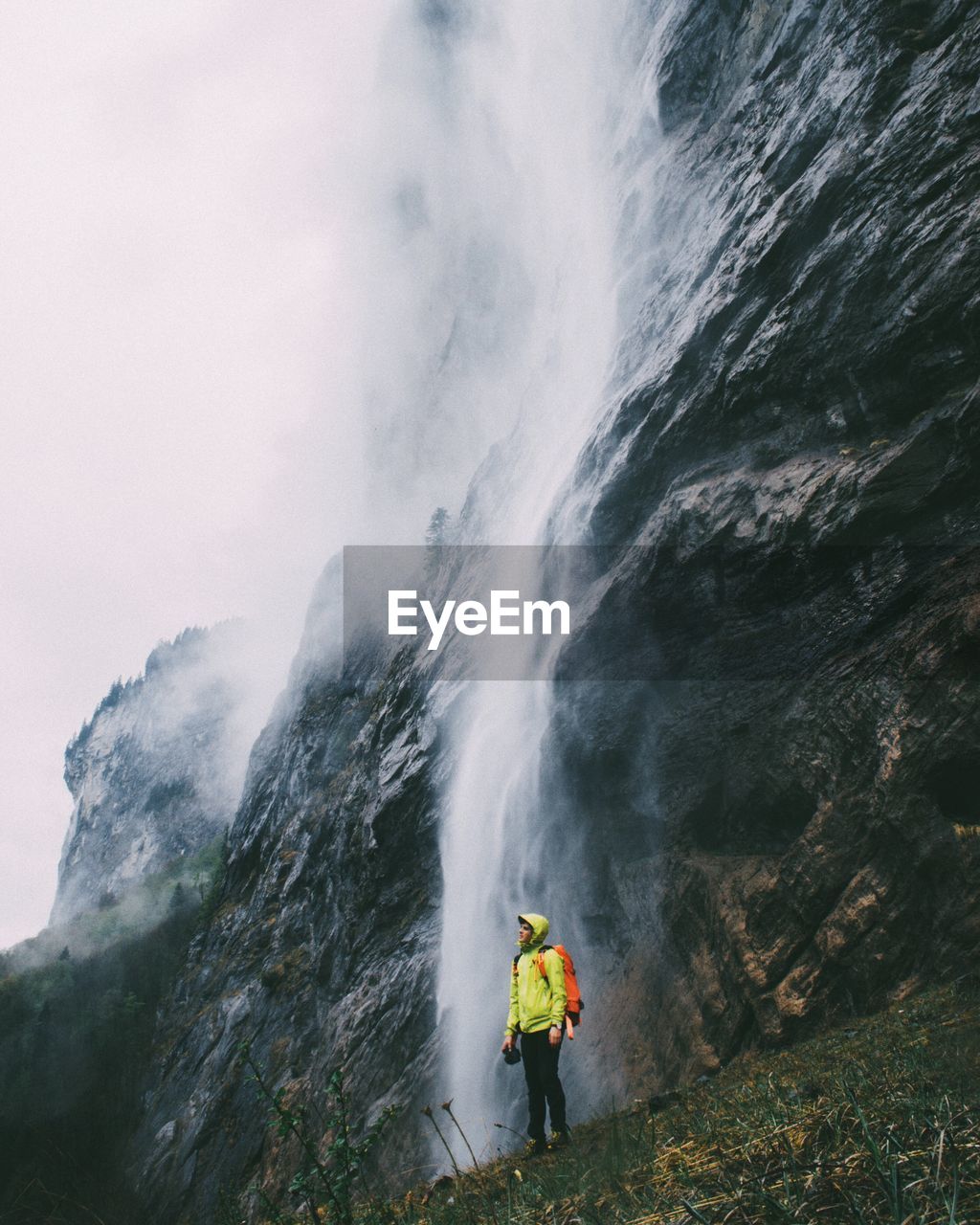 MAN STANDING ON MOUNTAIN