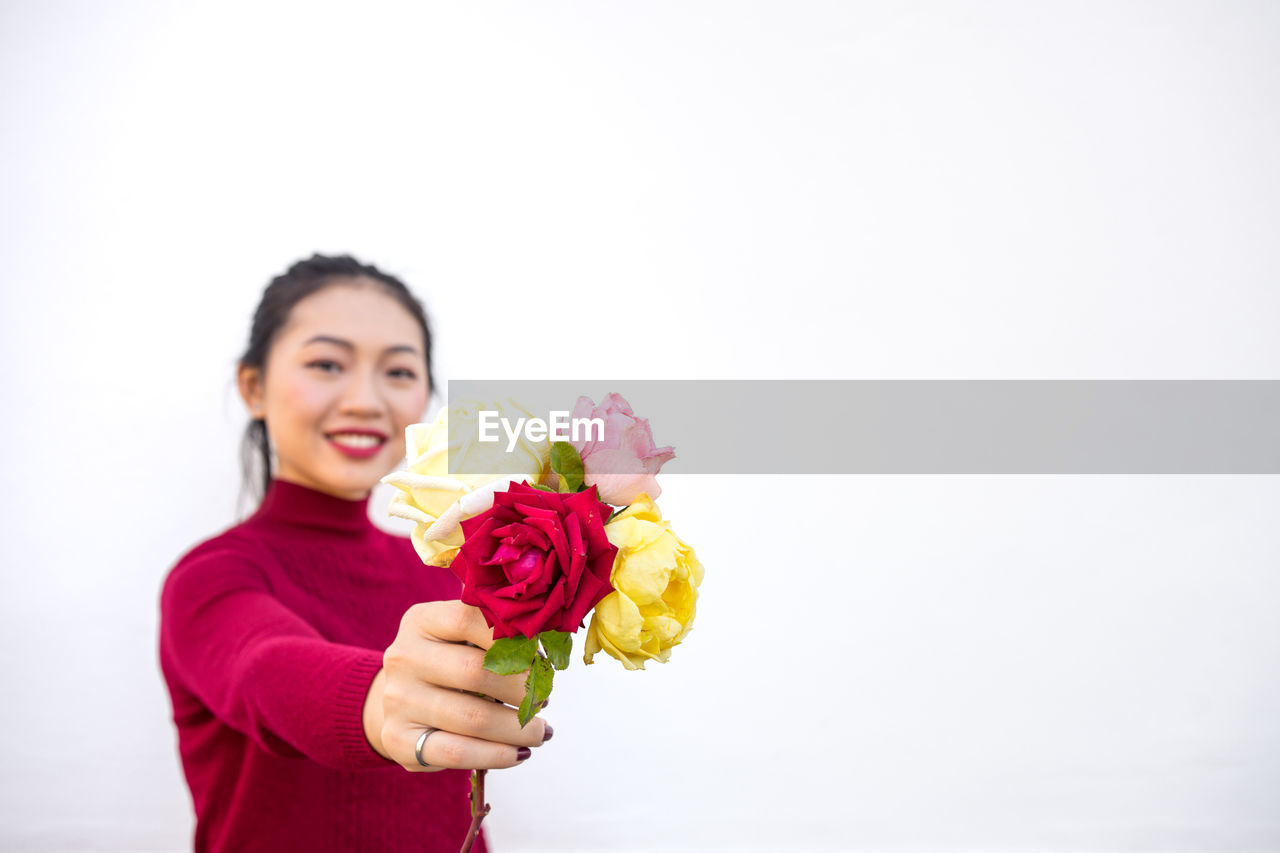 Asian lady showing rose bouquet at camera