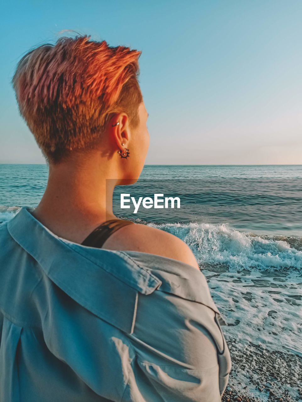 Woman looking at sea against clear sky